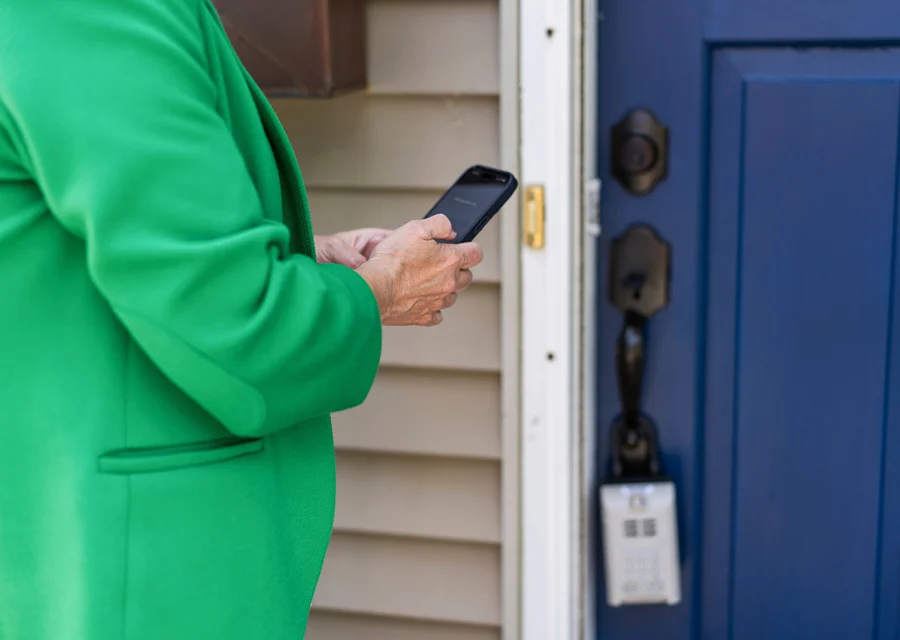 A person using a phone beside a front door