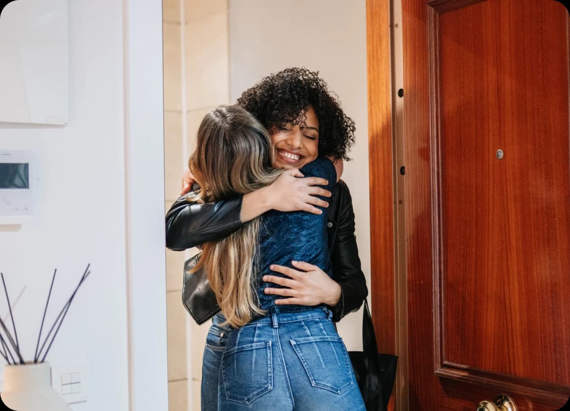 Two people greeting each other at home